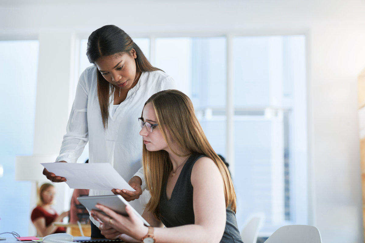 deux femmes qui regardent des documents