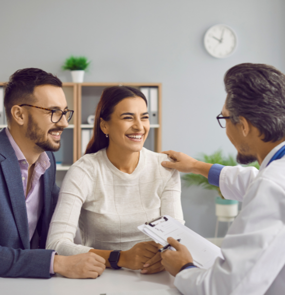 couple heureux face à un médecin